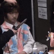 a man is getting his hair curled by a hairdresser .