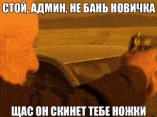 a man is holding a gun in front of a car with russian writing on it