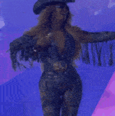 a woman wearing a cowboy hat is holding a microphone in her hand