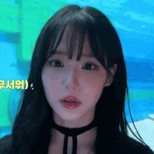 a girl with a choker around her neck looks at the camera with a blue background