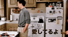 a man standing in a kitchen next to a refrigerator and stove with chinese writing on the refrigerator door