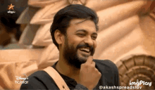 a man with a beard is laughing in a disney + hotstar ad
