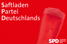 a red glass of beer with the word spd on the bottom