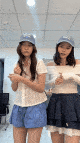 two women wearing hats that say ' la dodgers ' on them