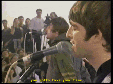 a man singing into a microphone with the words " you gotta take your time " above him