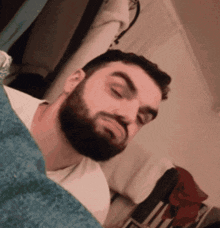 a man with a beard is laying on a bed
