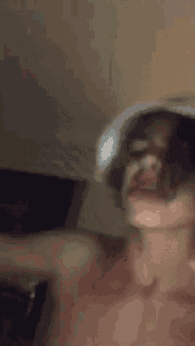 a man without a shirt is wearing a white hat on his head .