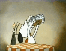snoopy is sitting at a table drinking a beer from a bottle .