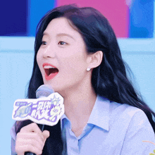 a woman with her mouth open is holding a microphone with a sign that says ' chinese ' on it