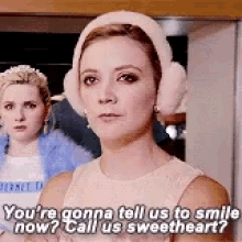 a woman wearing ear muffs and a hat is talking to a man .