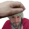 a man with a beard is being touched by a hand on his forehead .