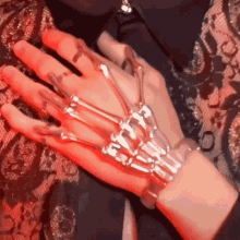 a close up of a person 's hand with a skeleton bracelet on it