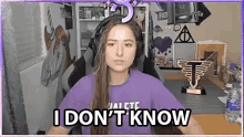 a woman wearing headphones and a purple shirt is sitting in a chair and says `` i don 't know ''