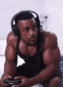 a man wearing headphones is playing a video game with the year 2018 in the background