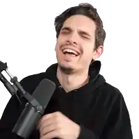a man wearing a black hoodie is laughing while holding a microphone