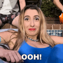 a woman in a blue bathing suit is making a funny face and the word ooh is on her chest