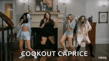 a group of women are dancing in front of a fireplace and singing into microphones .