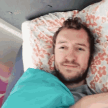 a man is laying in bed with a blue blanket