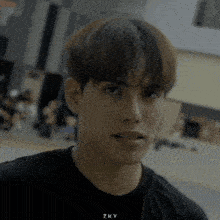 a young man wearing a black t-shirt with the word zky on it