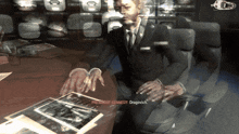 a man in a suit and tie is sitting at a table with a piece of paper that says " president kennedy dragovich "