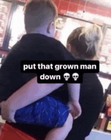 a man is holding a child in his arms with the caption put that grown man down