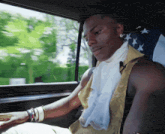 a man is sitting in a car with an american flag on the back seat