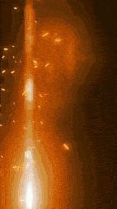 a candle is lit up in the dark with sparks flying around it