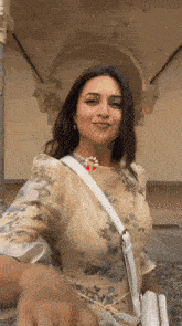a woman wearing a floral dress and a white purse