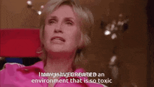 a woman in a pink shirt is talking about an environment that is so toxic .