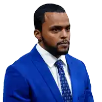 a man in a blue suit and tie looks to his left