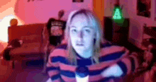 a woman is sitting in a living room with her arms crossed and looking at the camera .