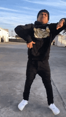 a man wearing a black sweatshirt with a gold logo on it