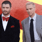 two men standing next to each other one wearing a red bow tie