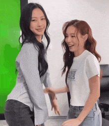 two women are standing next to each other and one has a shirt that says a better world