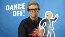 a man in a sticker giant shirt holds a cardboard cutout of a man