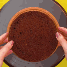 a person is holding a piece of chocolate cake