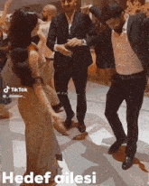 a group of people are dancing on a dance floor with the words hedef ailesi in the bottom right corner