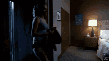 a woman is standing in a dark room with uc written on the bottom right