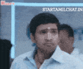 a man in a blue shirt is standing in front of a sign that says startamilchat.in