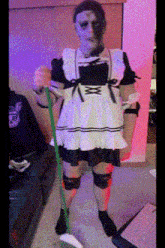a woman in a maid costume is holding a mop