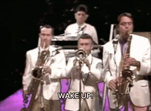 a group of men are playing instruments and the words wake up are on the screen