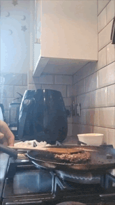 a person is cooking a hamburger in a frying pan