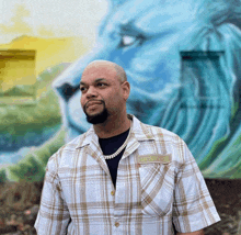 a man wearing a plaid shirt with mcmxviii written on the pocket