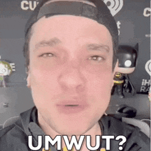 a man wearing a hat is making a funny face and saying umwut ?