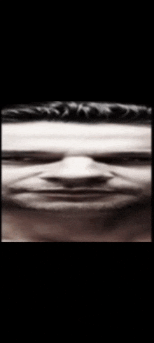 a black and white photo of a man 's face with a serious look on his face