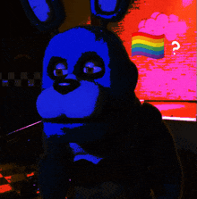 a blue bunny with a rainbow flag behind it