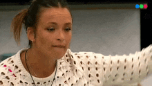 a woman wearing a white sweater and a nose ring