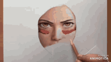 a person is drawing a woman 's face with red paint on her cheeks