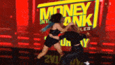 two women are fighting in front of a money in the bank sign