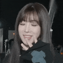 a close up of a woman 's face with her eyes closed and her hand on her face .